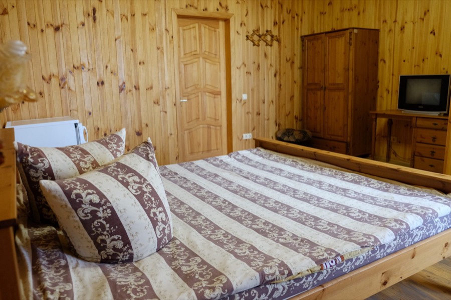 Ліжко з тканим покривалом у номері